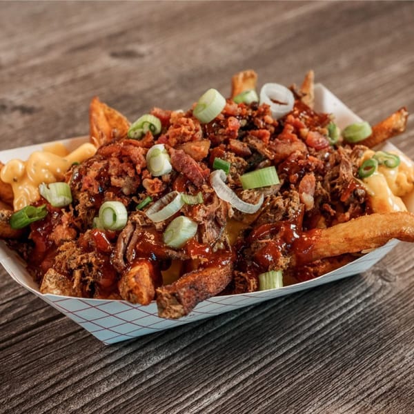 Bone Ends' BBQ fries loaded with pulled pork, cheese sauce, crispy onions, and green onions.