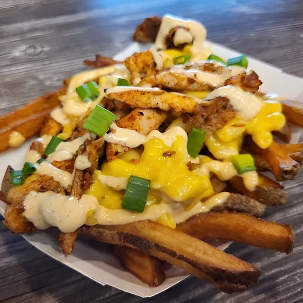 Bone Ends' loaded fries with chicken, melted cheese, creamy sauce, and green onions.